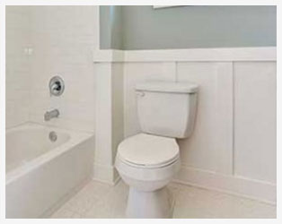 A white toilet sitting next to a bath tub.